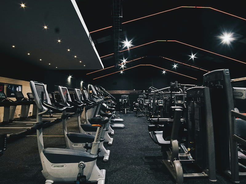 Área de cardio com fileiras de bicicletas e equipamentos modernos